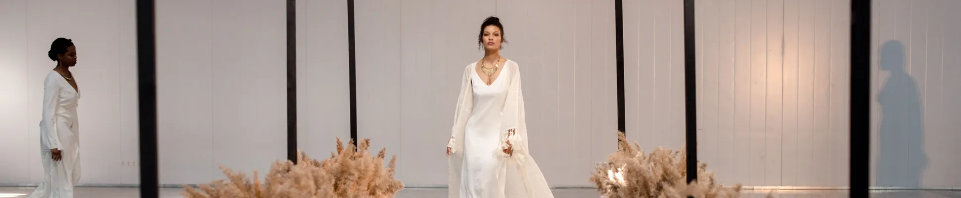 Een vrouwelijk model op de catwalk in witte kleding